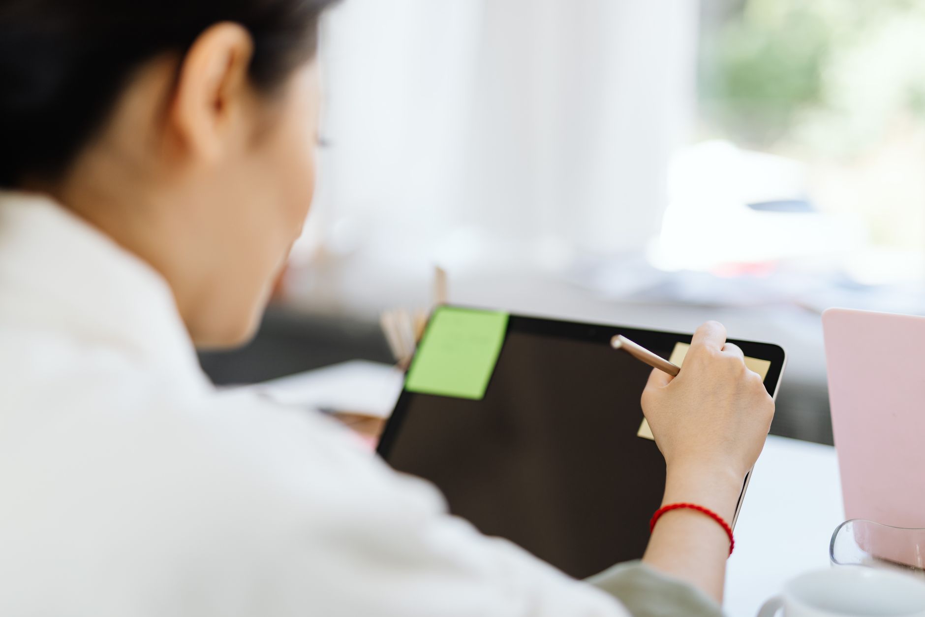 developer sketching wireframes on tablet with sticky notes